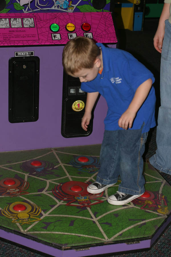 Mark stomping spiders [game at Chuck E. Cheese] (50mm, f/4.0, 1/60 sec, built-in flash)